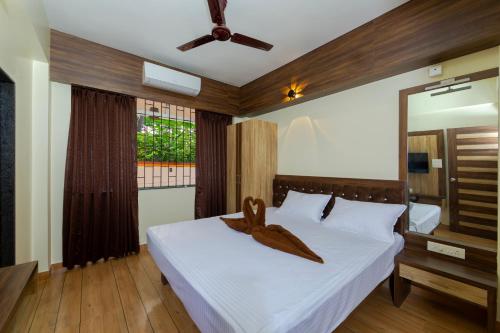 a bedroom with a bed with a towel on it at Lykke Suites- 2-min Drive to Colva Beach-By Goan Felicidade Hospitality PVT LTD in Colva