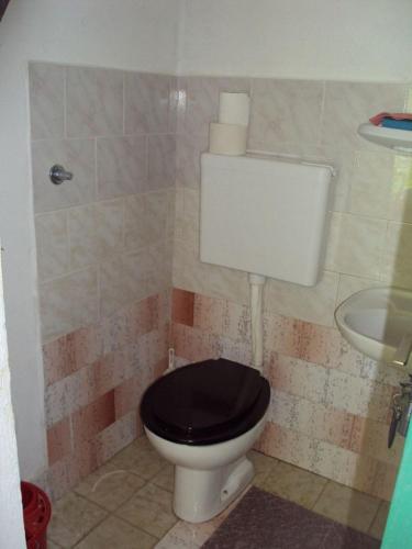 a bathroom with a toilet with a black seat and a sink at House Lidija in Postira