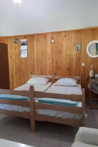 two beds in a room with wooden walls at House Lidija in Postira