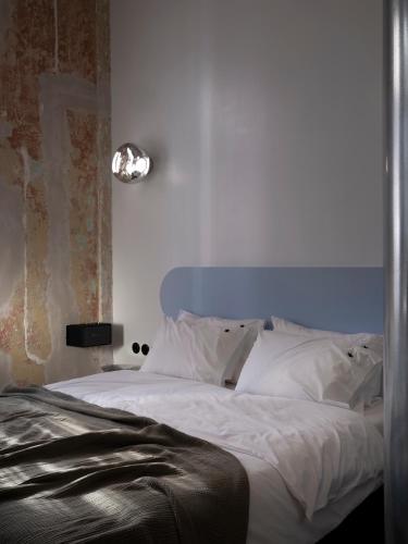 a bedroom with a large bed with white sheets at Hipsters Hotel in Thessaloniki