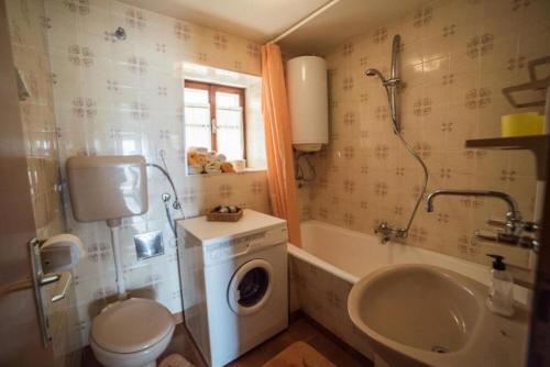 a bathroom with a washing machine and a sink at Apartments Ela in Sutivan