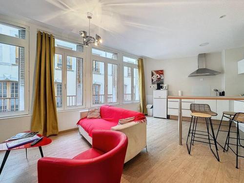 un salon avec un canapé rouge et une cuisine dans l'établissement F2 tout confort hyper cenrtre ST Rose, à Clermont-Ferrand