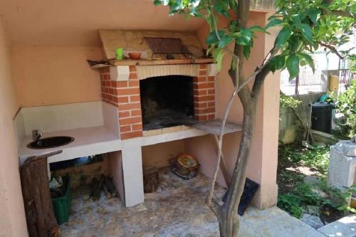a brick fireplace in a house with a sink at Apartments Brti in Supetar