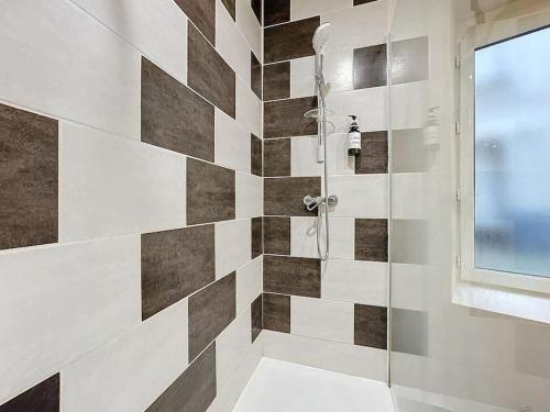 La salle de bains est pourvue d'une douche et d'un mur carrelé. dans l'établissement F2 tout confort hyper cenrtre ST Rose, à Clermont-Ferrand