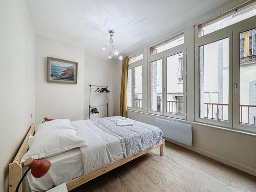 une chambre avec un lit et de grandes fenêtres dans l'établissement F2 tout confort hyper cenrtre ST Rose, à Clermont-Ferrand