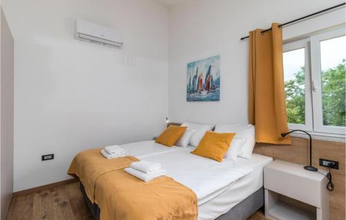 a bedroom with a bed and a window at 4 Bedroom Stunning Home In Lopar in Lopar