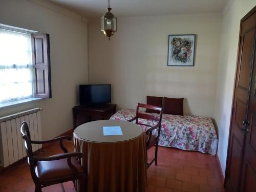 a room with a table and a bed and a window at Casas Do Zagão - Turismo Rural in Carregal do Sal