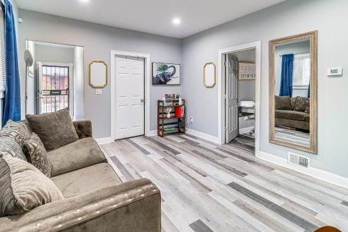 a living room with a couch and two mirrors at Downtown Detroit Townhome Near North End! in Detroit