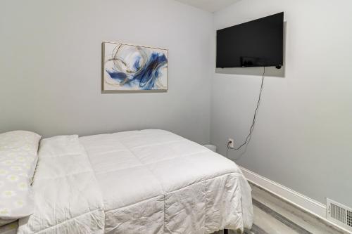 a bedroom with a bed and a flat screen tv at Downtown Detroit Townhome Near North End! in Detroit
