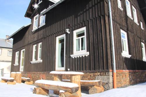 a black building with a bench in front of it at Fw. Steindöbra Anno Dazumal in Klingenthal