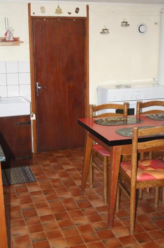 a kitchen with a table and chairs and a door at Studio confortable avec vue sur le lac - 30 m² - Gérardmer in Gérardmer