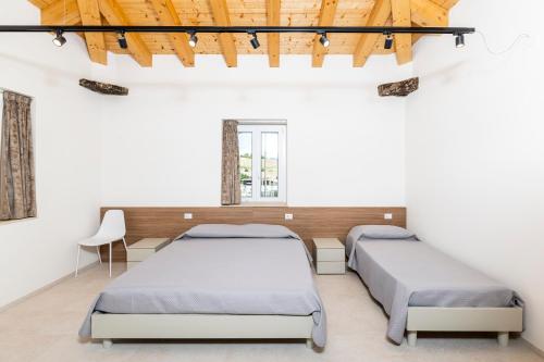 two beds in a room with white walls at Furrìa in Vizzini