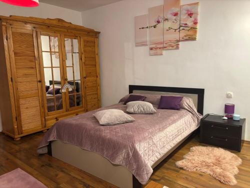 a bedroom with a bed and a wooden cabinet at E'milu Residence in Ghimbav
