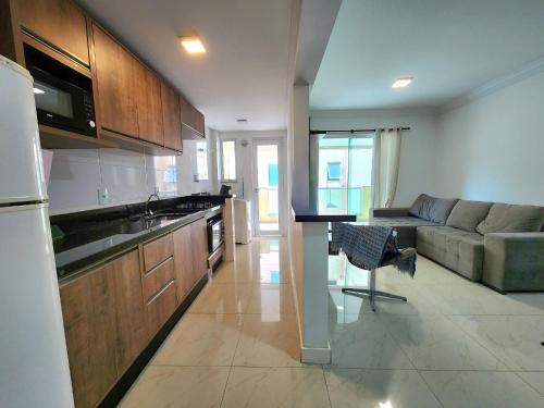 Una cocina y una sala de estar con un sofá. en Village Eco Park, en Bombinhas