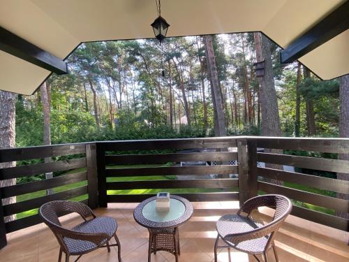 a patio with chairs and a table on a deck at Comfortable 4 bedroom villa outdoor wood-fired sauna Warsaw in Magdalenka