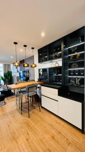 une cuisine avec une table en bois et une salle à manger dans l'établissement Appartement 50m de la plage et toutes commodités, plein centre ville et silencieux, à La Grande Motte