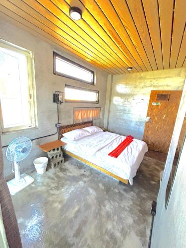 a bedroom with a bed in the middle of it at 巴斯拉岸民宿 in Chenggong