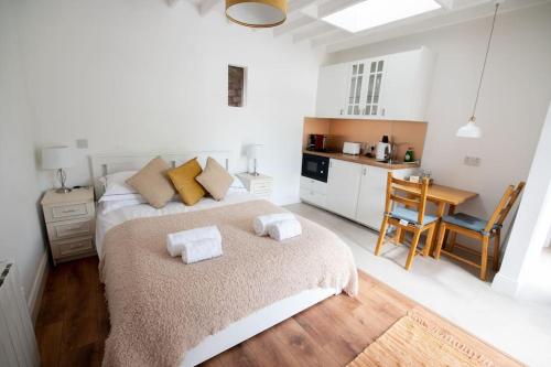 a white bedroom with a bed and a kitchen at The Oak Studio-Kilpatrick Glebe, Pet Friendly in Wexford