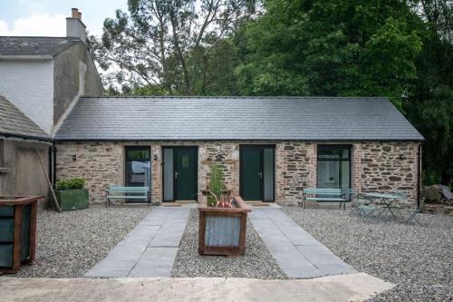 a stone cottage with two benches in front of it at The Oak Studio-Kilpatrick Glebe, Pet Friendly in Wexford