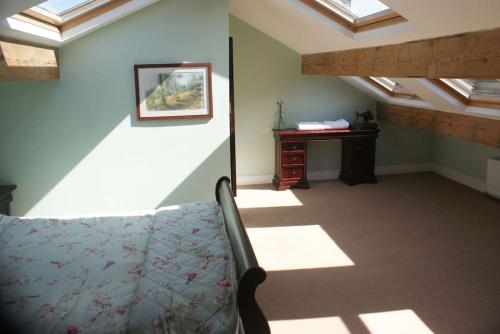 a attic room with skylights and a chair and a desk at The Sewing Room in Hebden Bridge