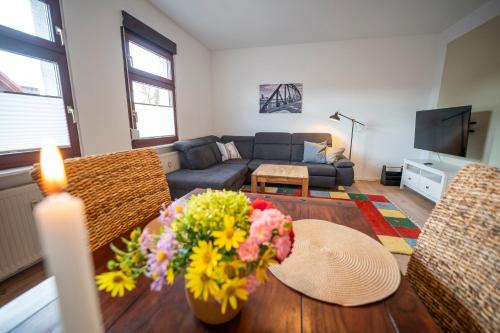 a living room with a table with flowers on it at Haus unterm Mammutbaum - Elberadweg in Magdeburg