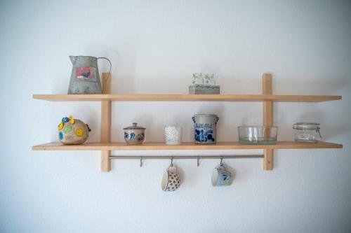 a wooden shelf with bowls and vases on it at Haus unterm Mammutbaum - Elberadweg in Magdeburg