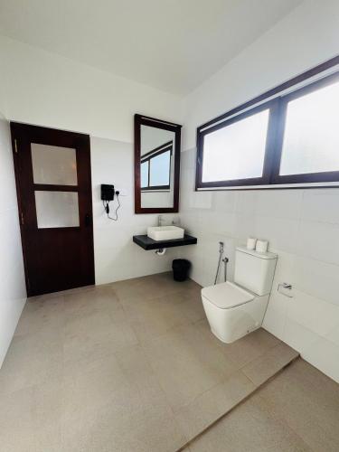 a bathroom with a toilet and a sink at Villa Red Lobster in Hikkaduwa