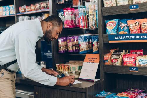 a man standing in a store looking at a shelf at Candlewood Suites Oxford - Anniston by IHG in Oxford