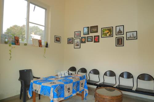 a room with a table with chairs and pictures on the wall at PRS CREEK SIDE HOME STAY VILLA in Yelagiri