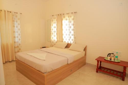 a bedroom with a bed with a window and a table at PRS CREEK SIDE HOME STAY VILLA in Yelagiri