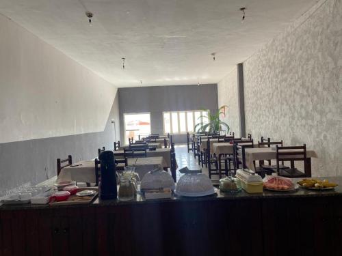a room with tables and chairs and a counter with food at Minas Hotel in Alcobaça