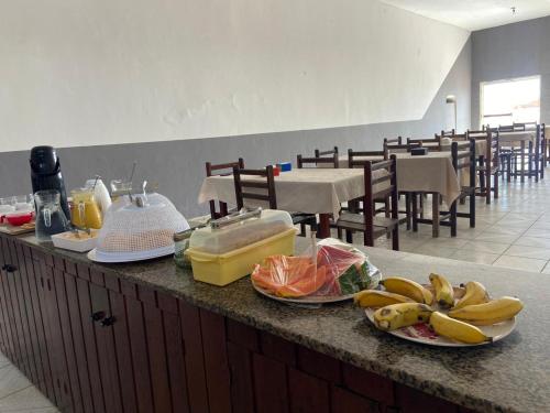 a kitchen with plates of food on a counter with tables at Minas Hotel in Alcobaça