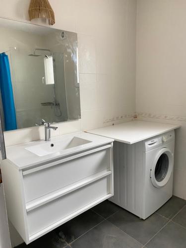 a white bathroom with a washing machine and a sink at Apartamento Berdica in Benitachell