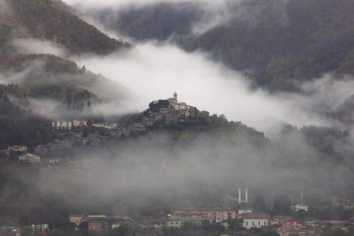 a house on top of a hill in the clouds at CIAK Affittacamere in Mulazzo