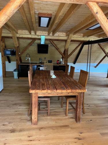 a wooden table with chairs in a large room at Apartmán typu Loft in Hořovičky