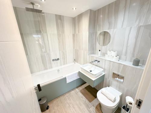 Un baño blanco con lavabo e inodoro. en Luxury 2 Bed - FREE Private Parking - Contractors, en Newcastle