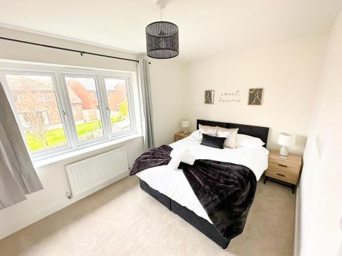 un dormitorio con una cama y una ventana en Luxury 2 Bed - FREE Private Parking - Contractors, en Newcastle