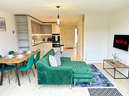 a living room with a green couch and a table at Luxury 2 Bed - FREE Private Parking - Contractors in Newcastle upon Tyne