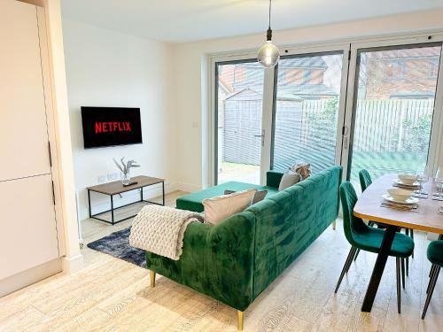 a living room with a green couch and a table at Luxury 2 Bed - FREE Private Parking - Contractors in Newcastle upon Tyne