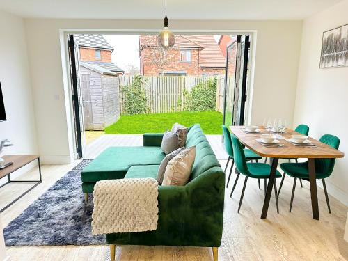 a living room with a green couch and a table at Luxury 2 Bed - FREE Private Parking - Contractors in Newcastle upon Tyne