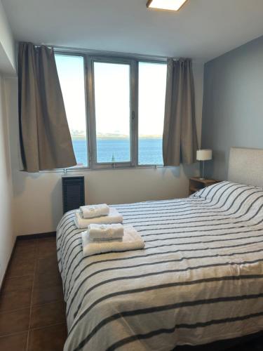 a bedroom with a bed with towels on it at Depto. Quelo in San Carlos de Bariloche