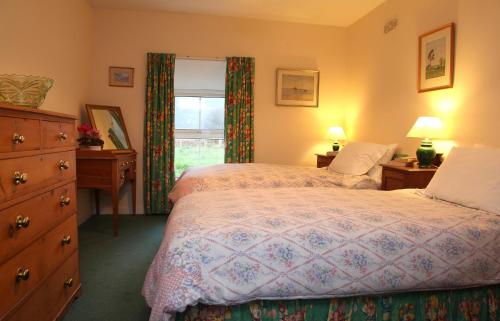 A bed or beds in a room at Inverawe Cottages