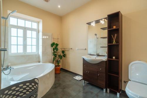 a bathroom with a tub and a sink at Villa Oasis Sea View - 3 Bedrooms in Funchal