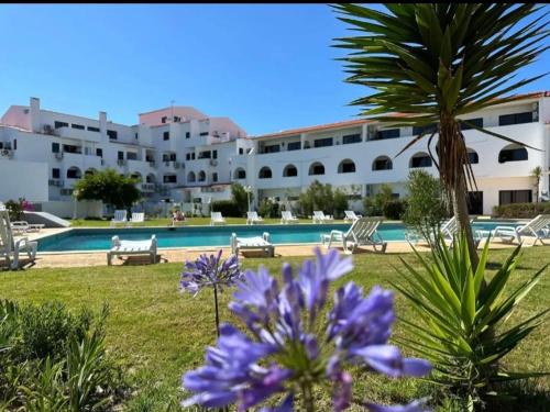 a resort with a swimming pool and purple flowers at Casa Papillon in Sagres