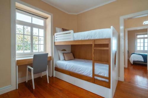 a bedroom with two bunk beds and a desk at Villa Oasis Sea View - 3 Bedrooms in Funchal