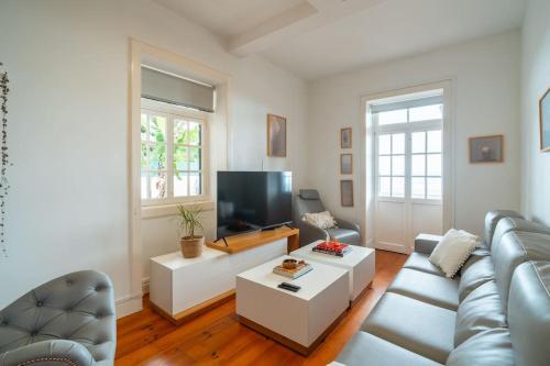 a living room with a couch and a tv at Villa Oasis Sea View - 3 Bedrooms in Funchal