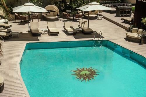 a swimming pool with chairs and tables and umbrellas at Holiday Inn Rosario by IHG in Rosario