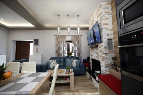 a living room with a blue couch and a fireplace at VENUS GUESTHOUSE in Portariá