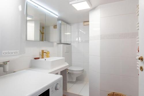 une salle de bain blanche avec un lavabo et des toilettes dans l'établissement 3 rooms, view on Paris roofs chic & cosy - 70 m2, à Paris