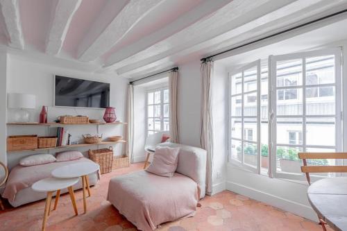 un salon avec une chaise et une fenêtre dans l'établissement 3 rooms, view on Paris roofs chic & cosy - 70 m2, à Paris